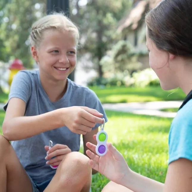 Sensorinis žaislas - raktų pakabukas „Simpl Dimpl“ (įvairių spalvų)